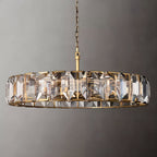 Clérachic large brass ring chandelier of clear faceted crystal panes with a brass rod and chain on a grey backdrop.