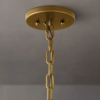 Clérachic brass ceiling canopy with two ball finials and a chain link, seen from below against a grey wall.