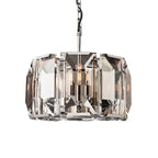 Clérachic compact polished steel drum chandelier with clear bevelled crystal panes and filament bulbs, on white.