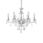 Clérachic six-light silver chandelier with curved glass arms, candle bulbs and crystal drops, shown on a white studio backdrop.