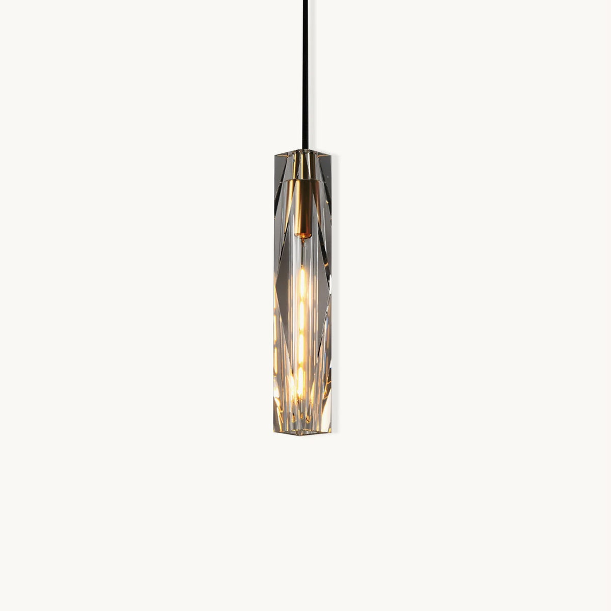 Slim Clérachic pendant with a faceted clear crystal shade, a brass-toned cap and a black cord, lit and shown on a plain white backdrop.
