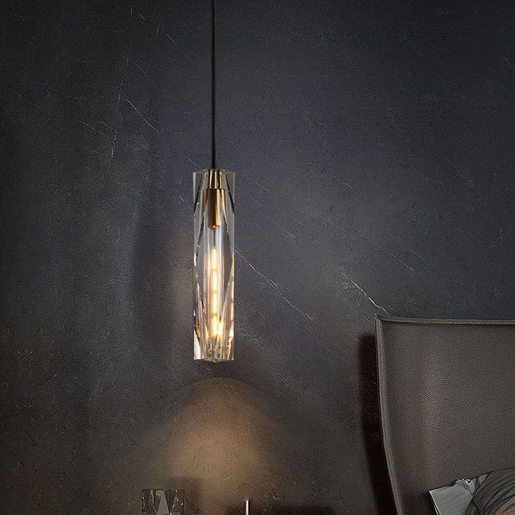 Faceted crystal Clérachic pendant glowing against a dark veined stone wall, casting a soft pool of light below it.