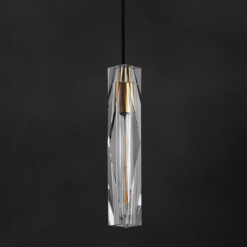 Close view of the faceted clear crystal shade on this Clérachic pendant, with its brass-toned cap and filament bulb on a dark ground.