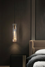 Clérachic crystal pendant hung beside a tan leather headboard and a black bedside cabinet, in a dim bedroom.