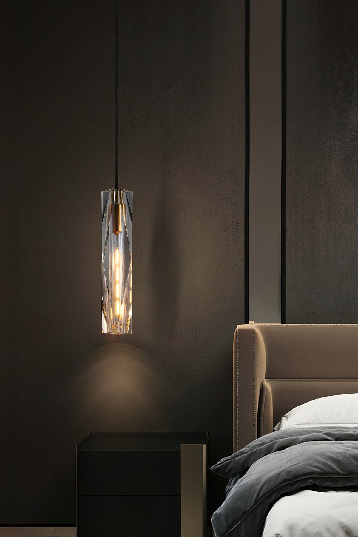 Clérachic crystal pendant hung beside a tan leather headboard and a black bedside cabinet, in a dim bedroom.