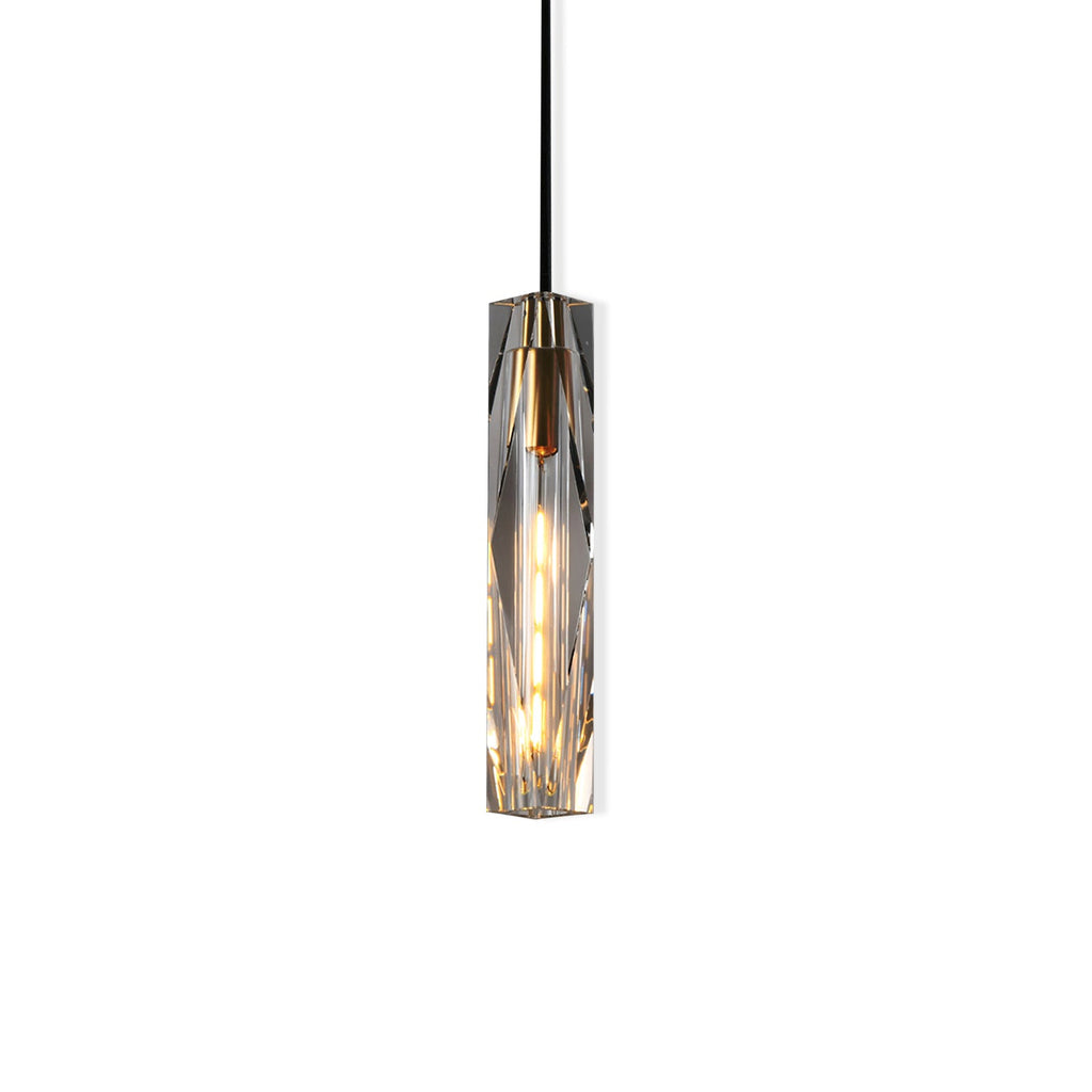 Clérachic pendant with a long faceted crystal shade, lit with a warm filament bulb, on a white background.