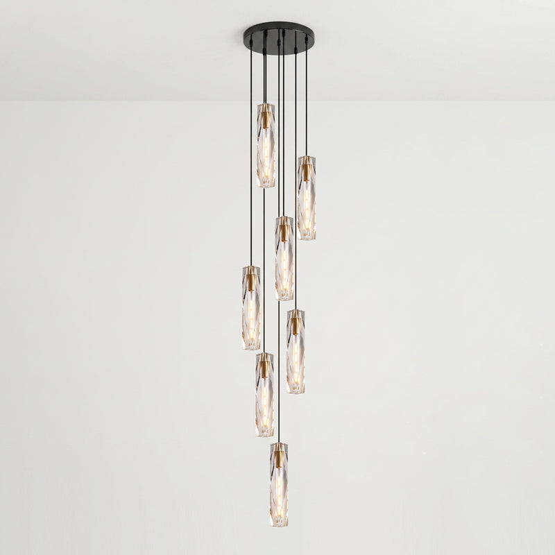 Seven Clérachic crystal pendants hung at different drops from one black ceiling plate, against a pale wall.