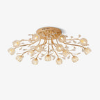 Gold flush ceiling light from Clérachic with branching stems, small crystal leaves and clear glass flower shades, on a plain white backdrop.