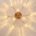 View from directly below of a gold Clérachic ceiling light, with glass flower shades on slim branches around a round canopy.