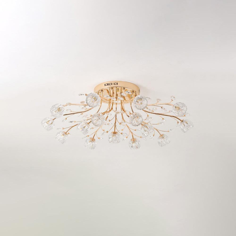 Unlit gold flush ceiling light from Clérachic with clear glass flower shades and crystal leaves, on a pale ceiling.
