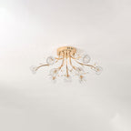 Smaller gold ceiling light from Clérachic with clear glass flower shades, unlit, mounted on a pale grey ceiling.