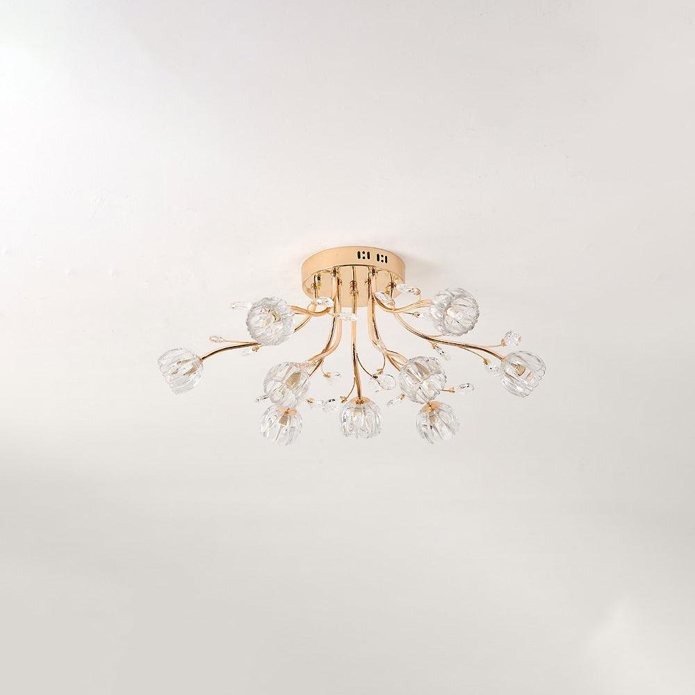 Smaller gold ceiling light from Clérachic with clear glass flower shades, unlit, mounted on a pale grey ceiling.