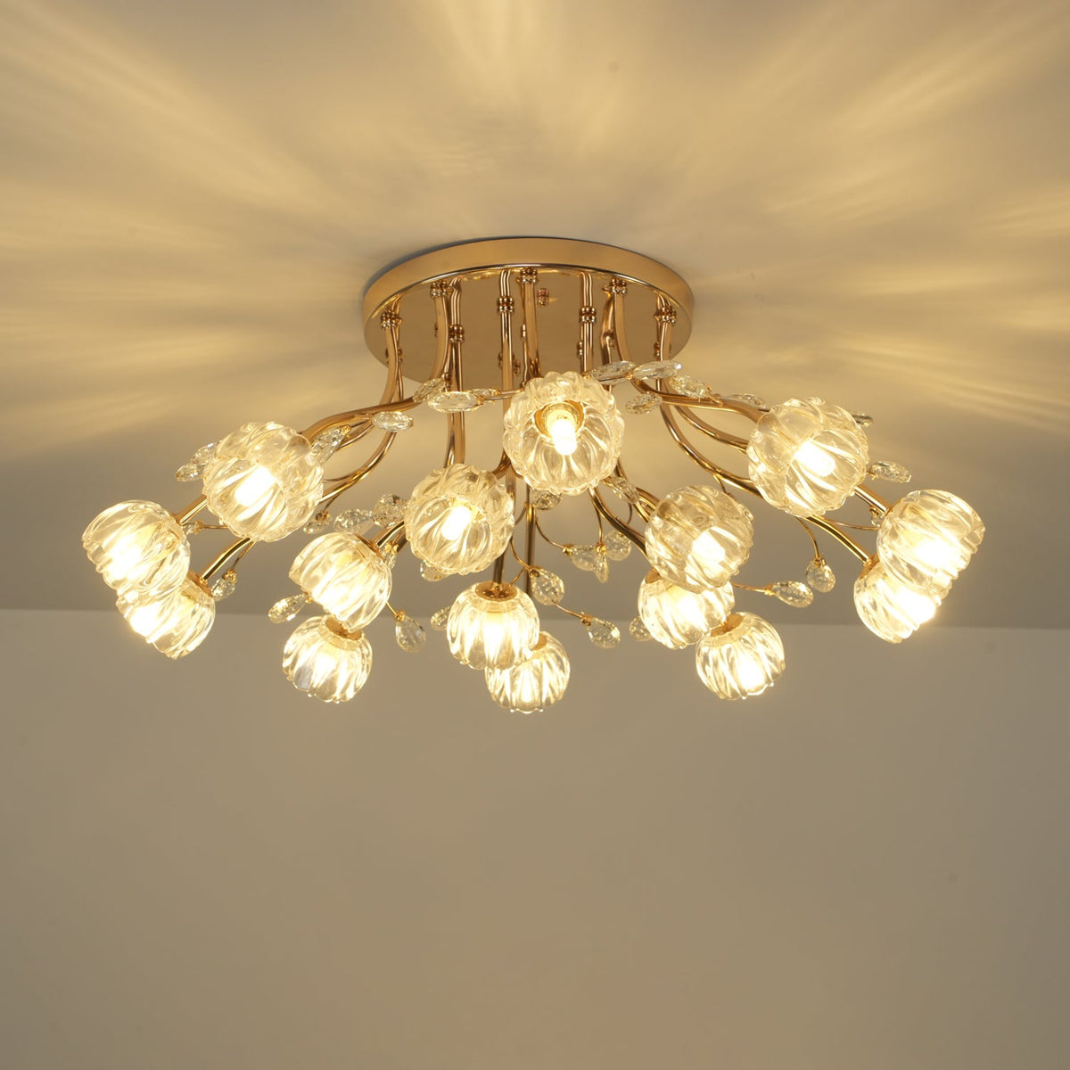 Lit gold flower-shade ceiling light from Clérachic, seen from a slight angle, with warm light reflecting off the ceiling.