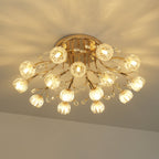 Lit gold ceiling light from Clérachic seen from below, with glass flower shades glowing warm against a patterned ceiling.
