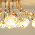 Close, lit view of ribbed glass flower shades and gold stems on this Clérachic ceiling light.