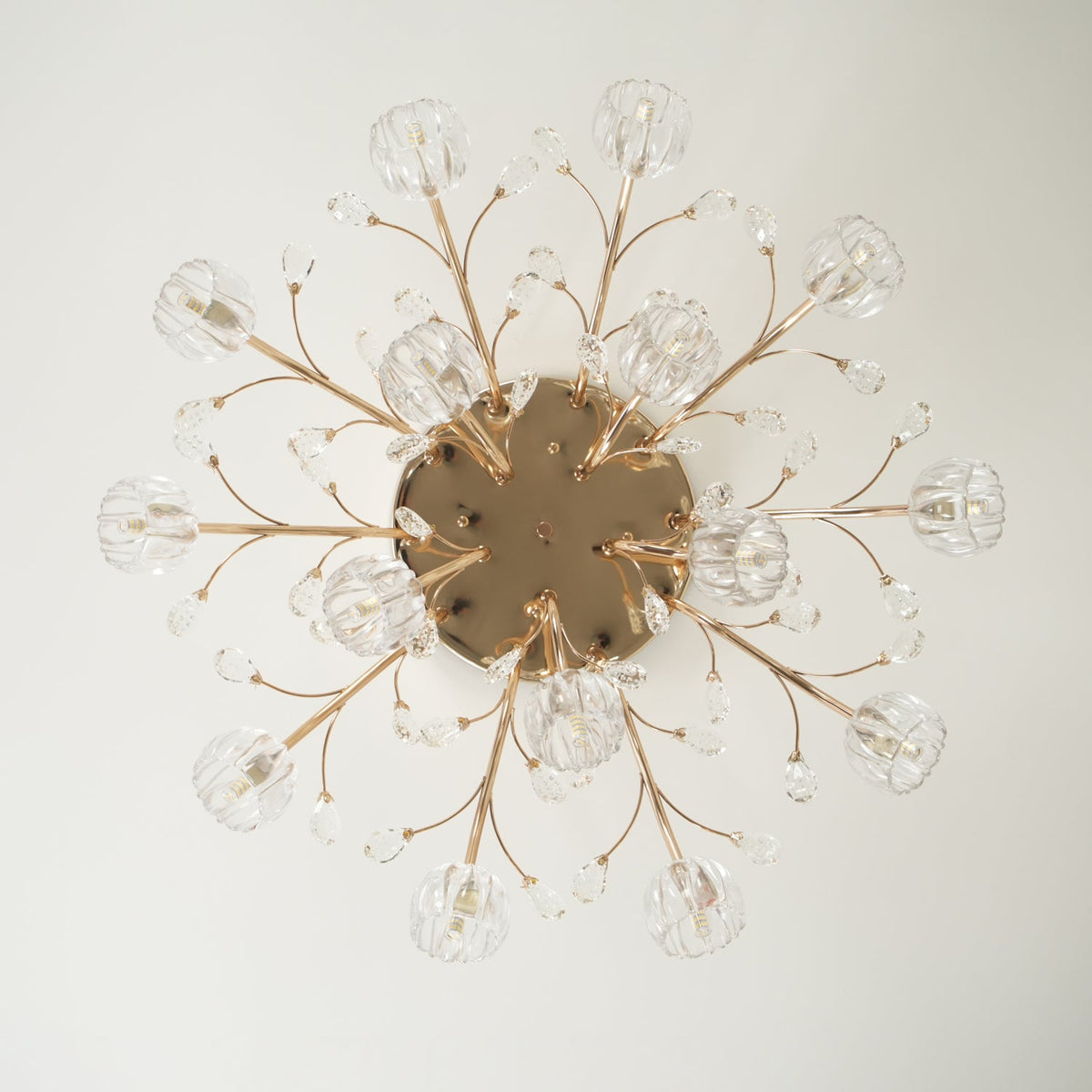 Unlit view from below of a gold Clérachic ceiling light, with branching stems and glass flowers around a round canopy.