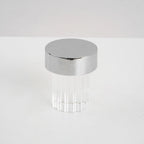 A fluted Clérachic lamp with a chrome cap on a pale tabletop, unlit, seen from slightly above.