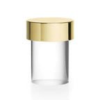 Large view of this Clérachic lamp on white, with a polished gold cap sitting over a clear, smooth glass cylinder.