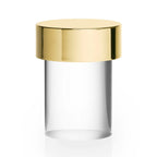 Large view of this Clérachic lamp on white, with a gold cap and clear smooth glass above a faintly lit base.