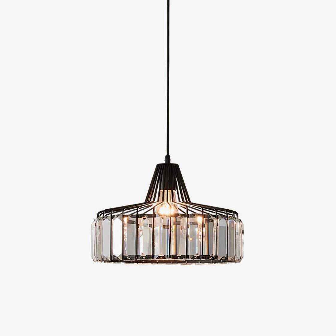 Black metal drum pendant from Clérachic with clear crystal glass prisms and a lit bulb, hanging on a plain white backdrop.