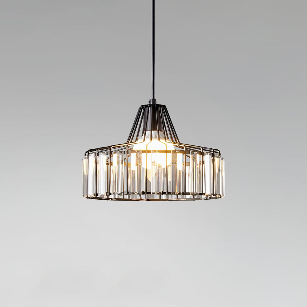 Close view of a black wire-framed crystal drum pendant from Clérachic, with its bulb glowing against a soft grey gradient.
