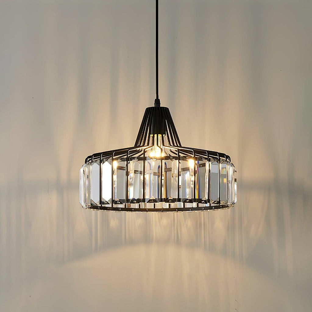 Warm light spills from this black Clérachic crystal drum pendant, throwing prism shadows across the wall and ceiling behind it.