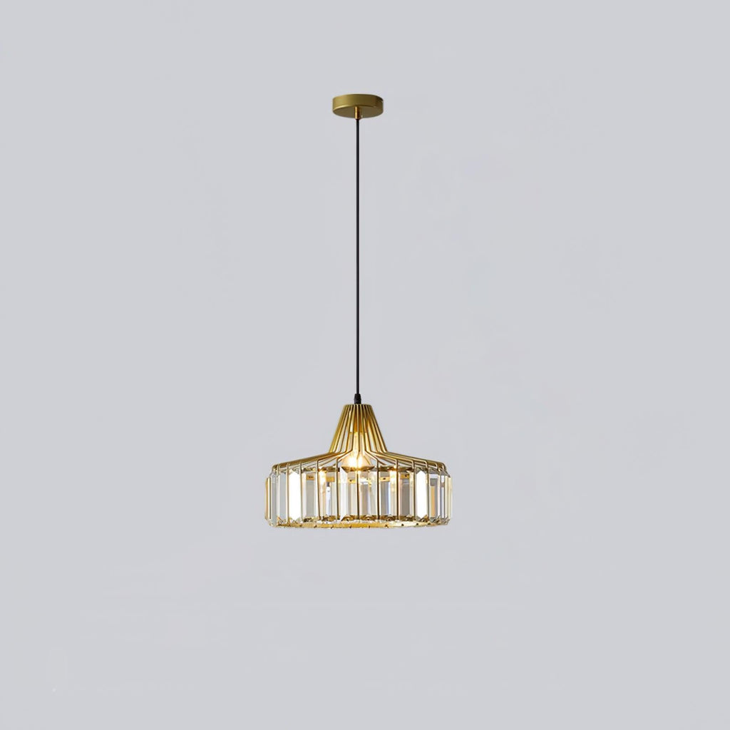 Gold crystal drum pendant from Clérachic on a gold ceiling plate, hung on a long black cable against a pale lilac-grey wall.