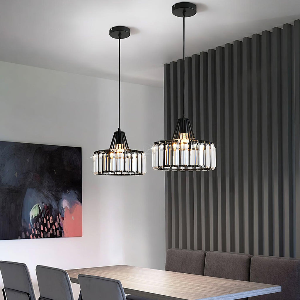 Two black crystal drum pendants from Clérachic, hung at different heights in a modern room with a dark slatted wall and a bold painting.
