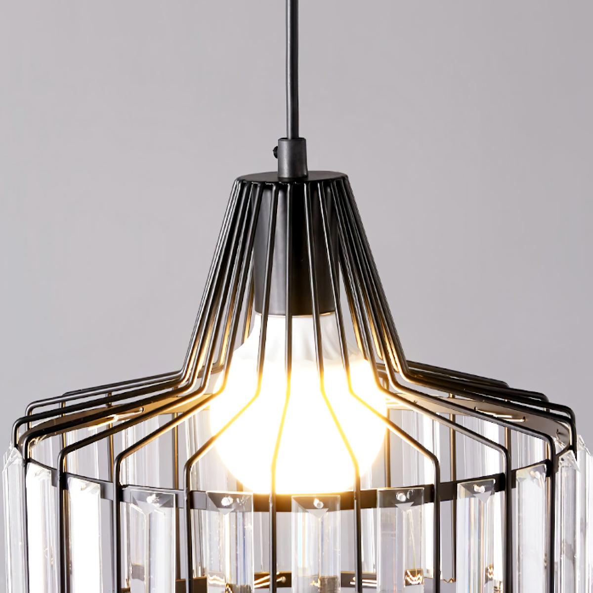 Underside view of the bulb and black wire cage of this Clérachic crystal drum pendant, with clear prisms around the lower edge.