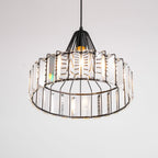 Upward view into the black drum pendant from Clérachic, showing the open base and the clear prisms ringed around the frame.