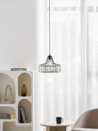 Small black crystal drum pendant from Clérachic in a bright room, with an arched white shelf and a table with a cup beneath.