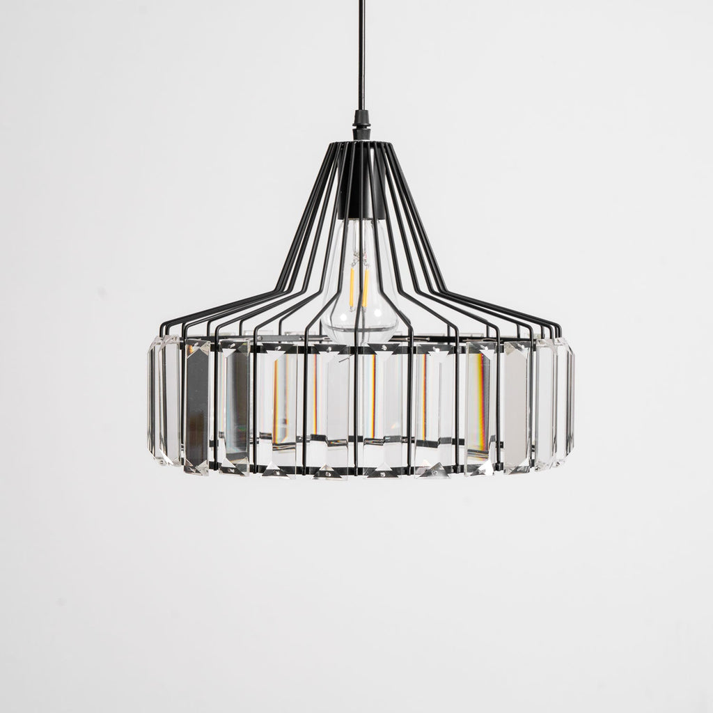 Black wire-framed crystal drum pendant from Clérachic, close and straight on, with clear prisms around the drum and a pale background.