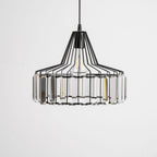 Black wire-framed crystal drum pendant from Clérachic, close and straight on, with clear prisms around the drum and a pale background.