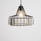 Large black crystal drum pendant from Clérachic, lit, seen close with every clear prism visible against a pale backdrop.