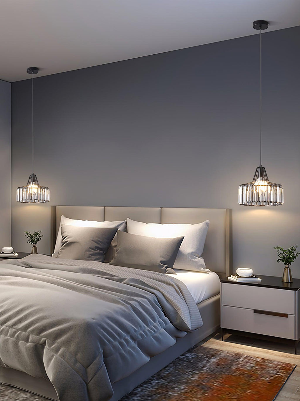Two black-framed crystal drum pendants from Clérachic hang either side of a double bed with grey bedding in a softly lit bedroom.