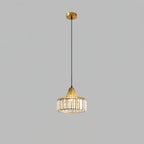 Gold crystal drum pendant from Clérachic on a gold ceiling plate and long cable, against a flat grey backdrop.