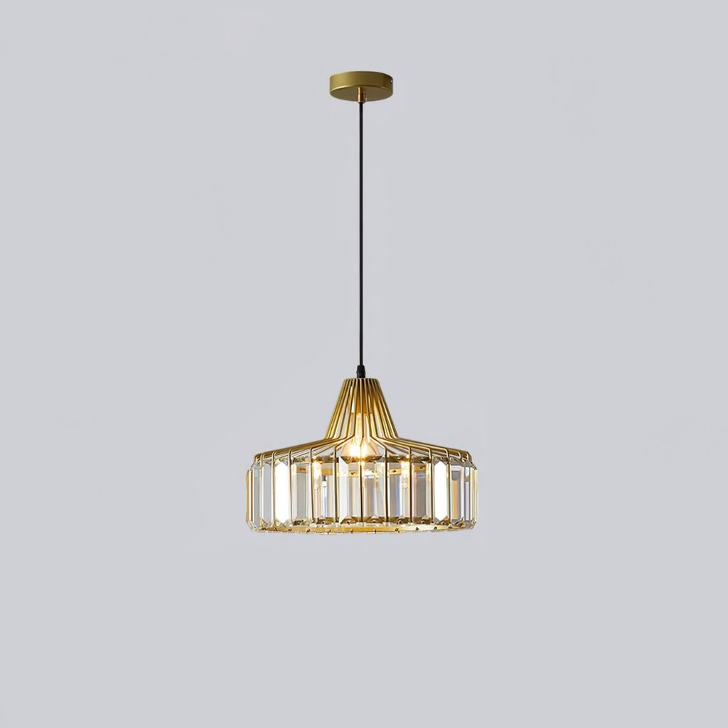 Gold crystal drum pendant from Clérachic with a gold ceiling plate, lit, hanging on a long black cable against a pale grey backdrop.