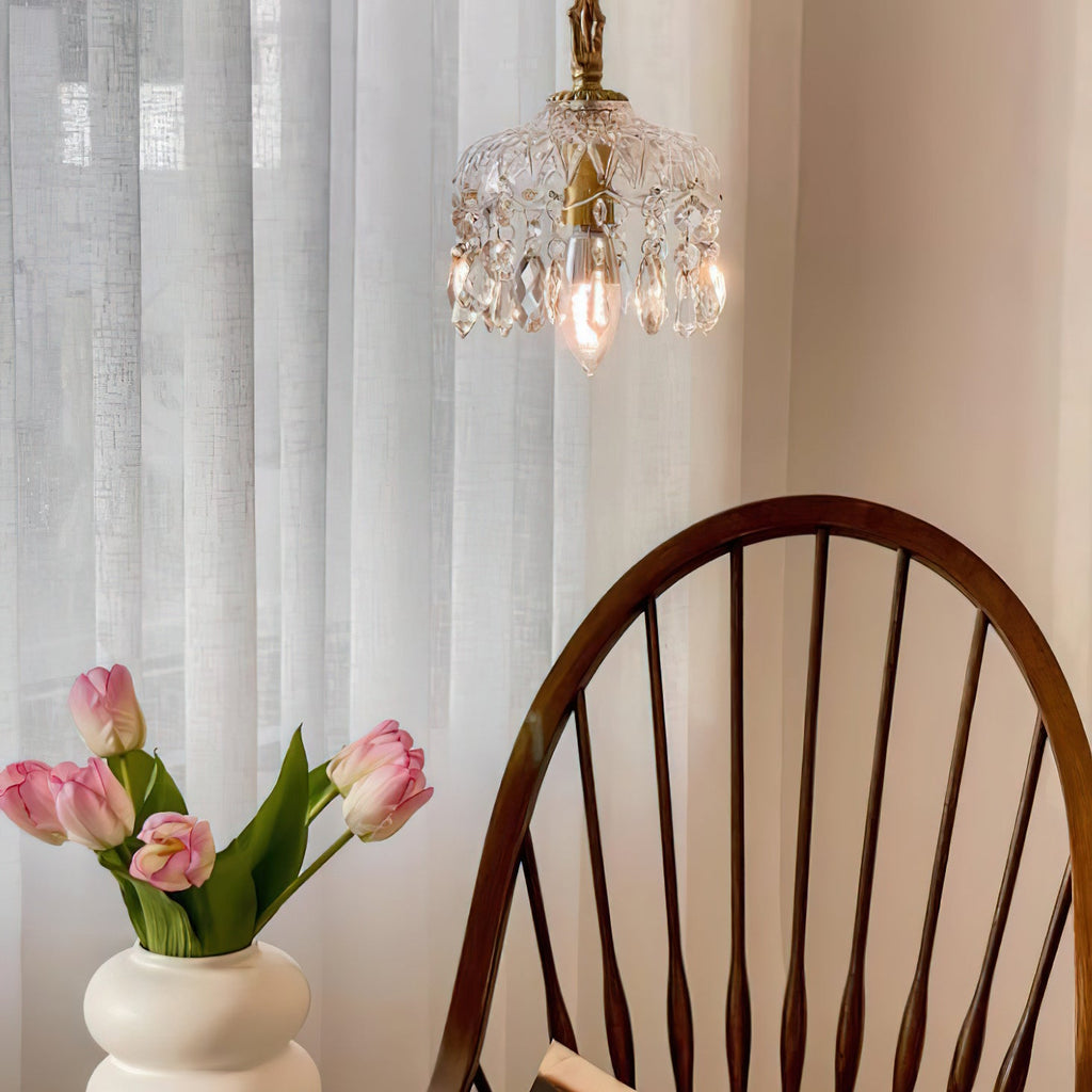 High in the frame, this Clérachic pendant light hangs by a sheer curtain, with pink tulips and a spindle-back chair below.