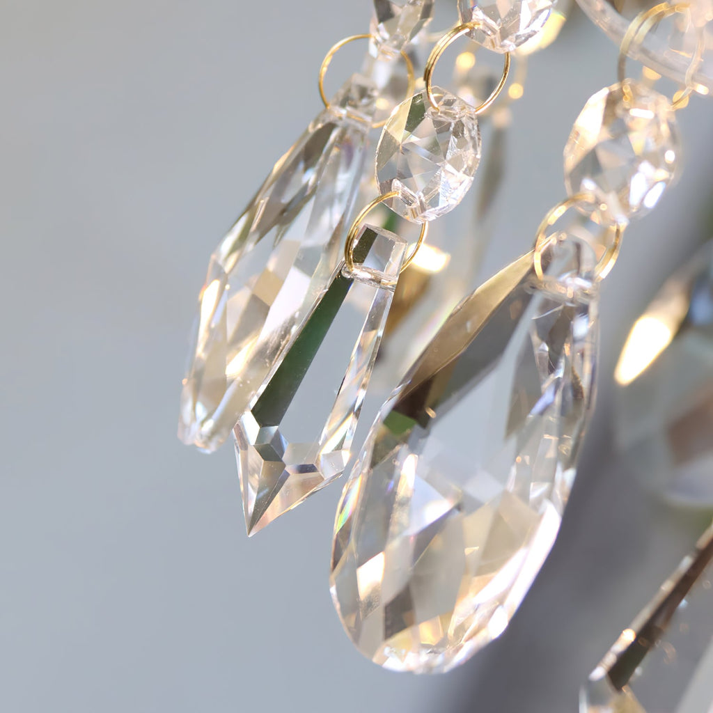Detail of faceted teardrop crystals on this Clérachic pendant light, each hung from fine gold-coloured rings.