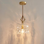 Lit against a softly rippled wall, this Clérachic pendant light hangs from a round gold ceiling plate on a twisted cord.