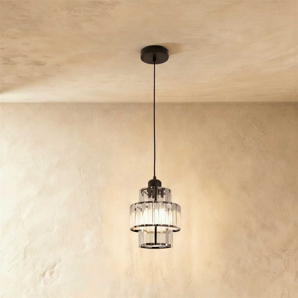 Clérachic tiered crystal pendant with a black canopy, cord and frame, glowing warmly against limewash plaster.