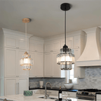Clérachic crystal pendants in gold and black frames side by side above a marble kitchen island.