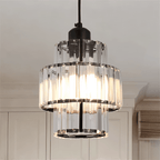Close view of a Clérachic crystal pendant with a black frame, its three tiers of glass bars glowing from within.
