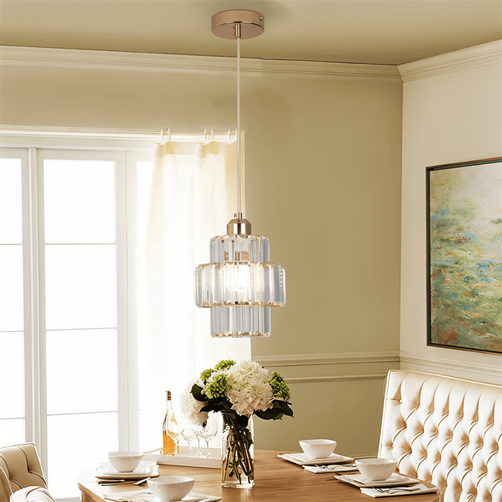 Clérachic gold crystal pendant on a white cord above a set dining table with hydrangeas and tufted seating.