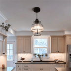 Clérachic black-framed crystal pendant hung over a kitchen sink under a window, with cream shaker cabinets.
