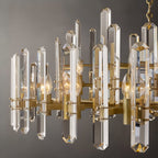 Clérachic close view of crystal rods, brass arms and candle-style bulbs on a round chandelier.