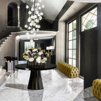 In a grand entrance hall with a marble floor, this Clérachic pendant cluster hangs above a round black table with a large flower arrangement.