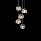 Five larger clear glass heads on this Clérachic pendant hang on pale cords against black.