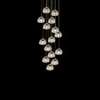 About fifteen clear glass heads from this Clérachic pendant hang on cords in a loose cluster against black.