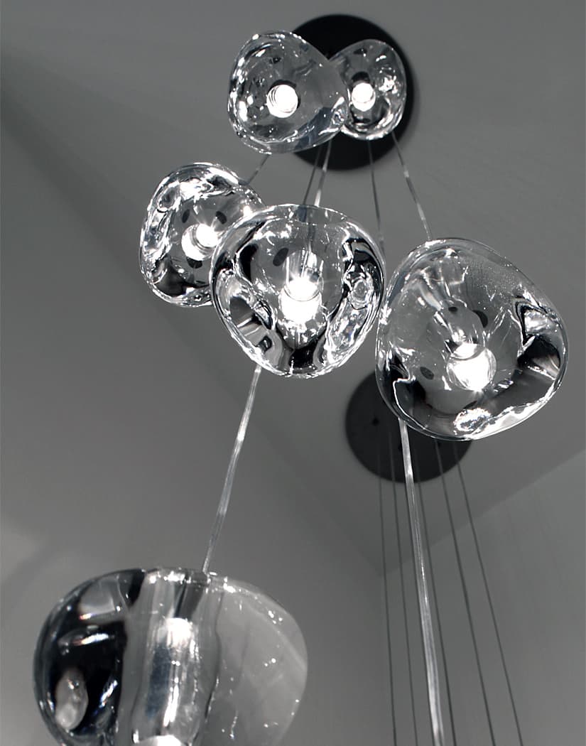 Looking up at a black ceiling canopy, this Clérachic pendant's clear glass heads cluster close together before the wires drop away.